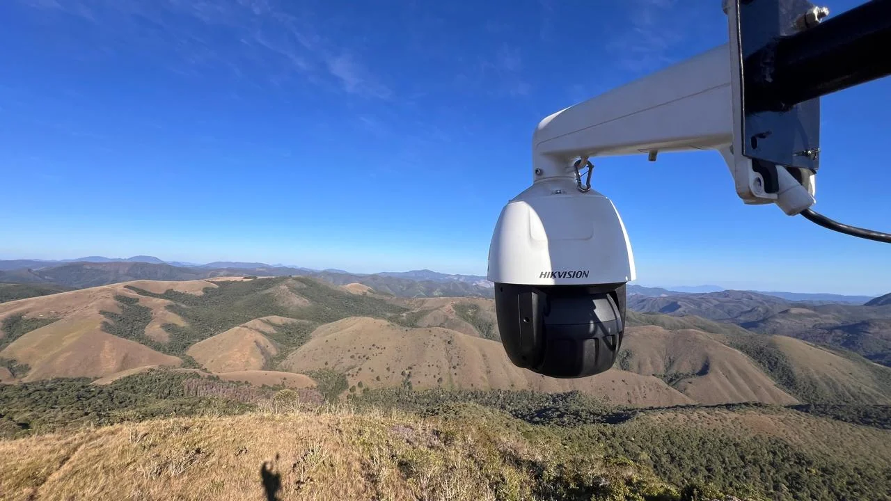Câmera PTZ de alta resolução do SMAIF instalada no alto de uma torre, com a serra da Mantiqueira ao fundo
