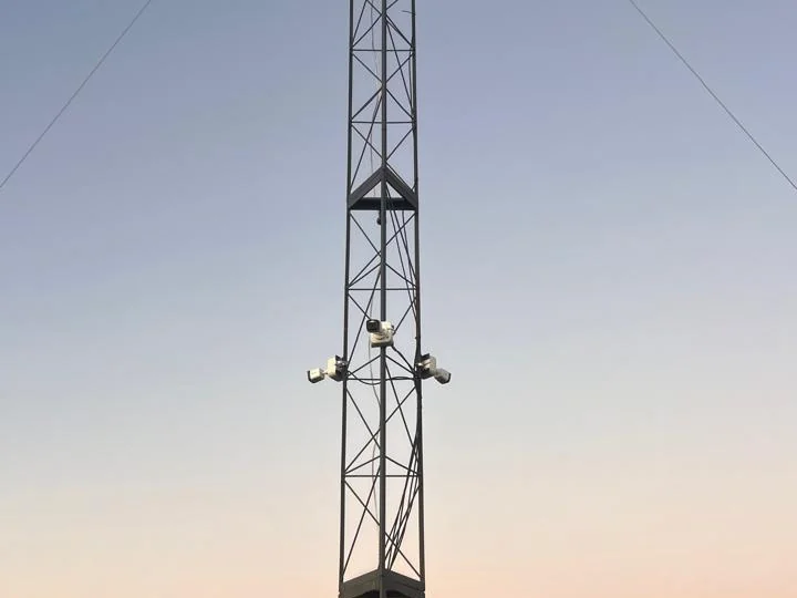 Torre do SMAIF ao entardecer, com as câmeras, a antena de radiocomunicação e o abrigo dos equipamentos